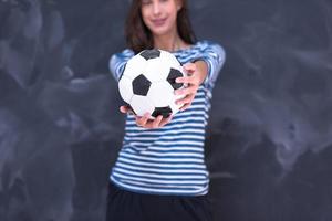 femme tenant un ballon de football devant une planche à dessin à la craie photo