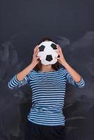 femme tenant un ballon de football devant une planche à dessin à la craie photo