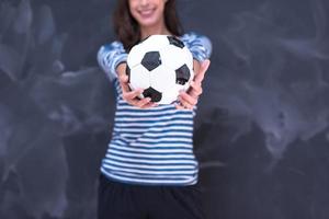 femme tenant un ballon de football devant une planche à dessin à la craie photo