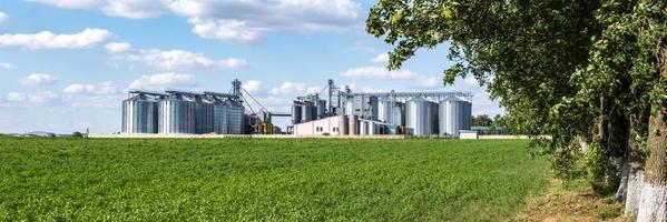 ascenseur de grenier moderne. silos d'argent sur l'agro-industrie et l'usine de fabrication pour le traitement, le nettoyage à sec et le stockage des produits agricoles, de la farine, des céréales et des grains. photo