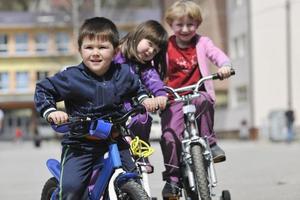 groupe d'enfants heureux apprenant à conduire un vélo photo