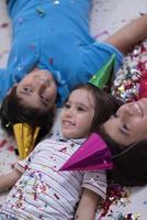 enfants soufflant des confettis allongés sur le sol photo