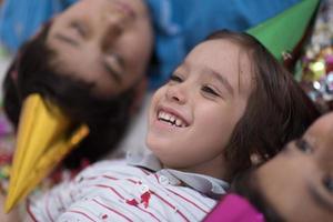 enfants soufflant des confettis allongés sur le sol photo