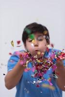 enfant soufflant des confettis photo