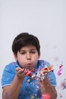 enfant soufflant des confettis photo