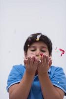 enfant soufflant des confettis photo