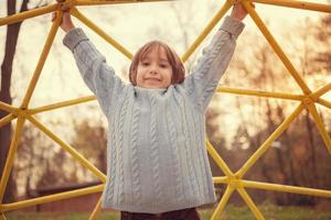 mignon petit garçon s'amusant dans l'aire de jeux photo