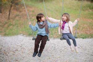 les enfants se balancent dans le parc photo