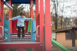 mignon petit garçon s'amusant dans l'aire de jeux photo