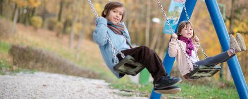 les enfants se balancent dans le parc photo