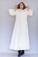 Femme en blouse blanche avec capuche isolé sur fond blanc photo