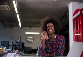 portrait d'une jeune femme afro-américaine réussie dans un bureau moderne photo