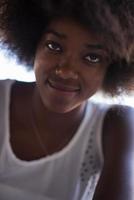 portrait en gros plan d'une belle jeune femme afro-américaine souriante et levant les yeux photo