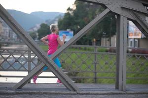 femme sportive courant sur le trottoir photo