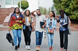 groupe de cinq étudiants africains qui passent du temps ensemble sur le campus de la cour universitaire. amis afro noirs qui étudient. thème de l'éducation. photo