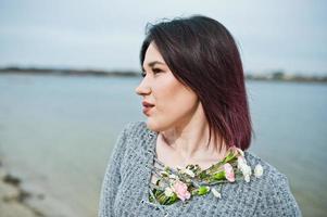 portrait de jeune fille brune en robe grise fond le lac. photo