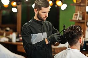 bel homme barbu au salon de coiffure, coiffeur au travail. photo