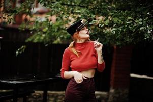 portrait de mode de fille sexy rousse en plein air. modèle attrayant séduction femme avec cigarette. photo