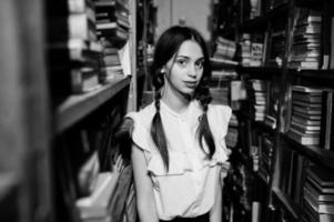 fille avec des nattes en blouse blanche à l'ancienne bibliothèque. photo