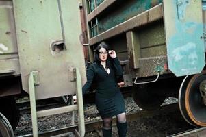 fille brune porter en noir avec des lunettes dans la gare. photo