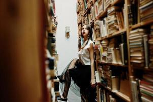 fille avec des nattes en blouse blanche à l'ancienne bibliothèque. photo