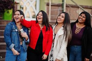 groupe de quatre filles latinos heureuses et jolies de l'équateur posées dans la rue. photo