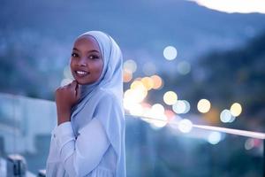 femme musulmane africaine moderne dans la nuit au balcon photo