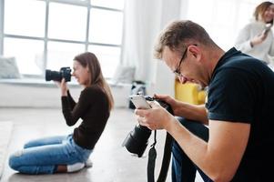 l'équipe de deux photographes prenant des photos en studio. photographe professionnel sur le travail.