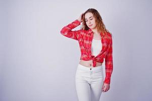 jeune fille en chemise à carreaux rouge et pantalon blanc sur fond blanc en studio. photo