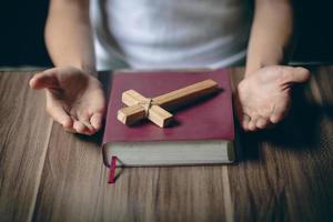 femme priant avec sa bible sur la table. prier pour les bénédictions de Dieu. photo