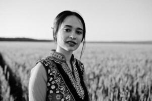 tendre fille indienne en sari, avec des lèvres violettes maquillées posées sur le terrain au coucher du soleil. modèle indien à la mode. photo