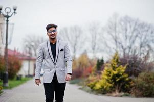 homme indien élégant avec bindi sur le front et lunettes, porter sur costume posé à l'extérieur. photo