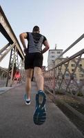 homme faisant du jogging sur le pont le matin ensoleillé photo