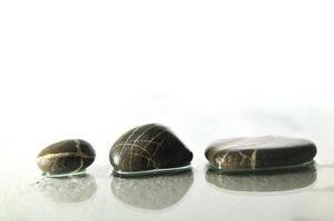 pierres zen humides isolées avec des éclaboussures de gouttes d'eau photo
