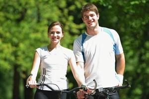 couple heureux à vélo à l'extérieur photo