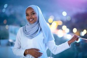 femme musulmane africaine moderne dans la nuit au balcon photo
