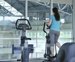 les gens qui courent sur un moulin à fil au club de remise en forme photo