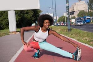 portrait d'une jeune femme afro-américaine sportive qui s'étend à l'extérieur photo