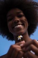 portrait d'une fille afro-américaine avec une fleur à la main photo