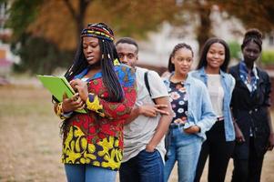 rangée d'étudiants africains du groupe cinq passant du temps ensemble sur le campus de la cour de l'université. amis afro noirs qui étudient. thème de l'éducation. photo