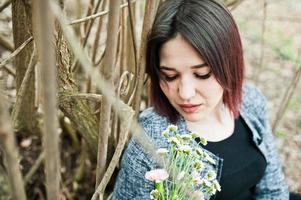 portrait de jeune fille brune en robe noire au bois de printemps. photo