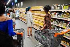 groupe de femmes africaines achetant une bouteille d'huile de tournesol au supermarché. photo