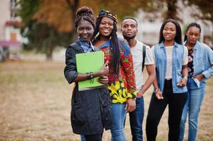 rangée d'étudiants africains du groupe cinq passant du temps ensemble sur le campus de la cour de l'université. amis afro noirs qui étudient. thème de l'éducation. photo