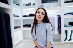 fille magnifique brune dans la boutique du magasin de vêtements à des vêtements décontractés. photo