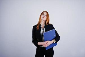 portrait d'une femme d'affaires rousse portant un chemisier rayé et une veste avec un dossier bleu. photo