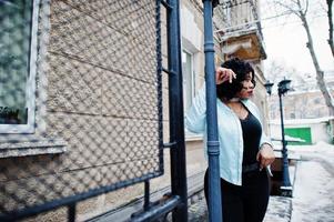 élégant modèle de taille plus afro-américain dans les rues de la ville le jour de l'hiver. photo