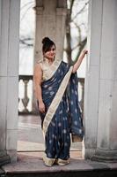 élégante fille indienne sud-asiatique brune en sari debout sous l'arche. photo