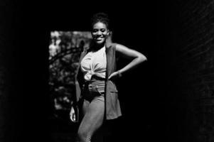 élégante femme afro-américaine posée sur l'arc de tonnel à la journée ensoleillée. photo