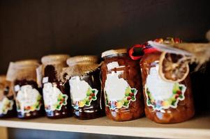 bocaux en verre avec différents types de confiture et de baies d'un supermarché ou d'une épicerie. produits de conserve maison. fait avec amour. photo