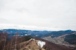 vallées de montagne enneigées dans les carpates. vue sur les carpates ukrainiennes et yaremche depuis le sommet de makovitsa. photo